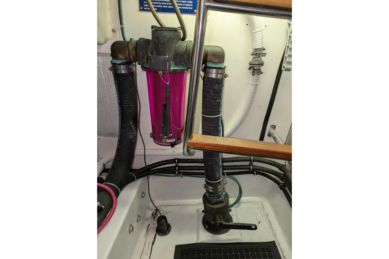 Slide: The Image of Engine room of a 2005 American Tug 41, featuring hoses and a filter system. - 83