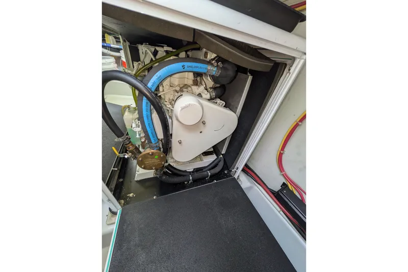 Slide: The Image of Engine compartment of a 2005 American Tug 41, showcasing mechanical components and wiring. - 84