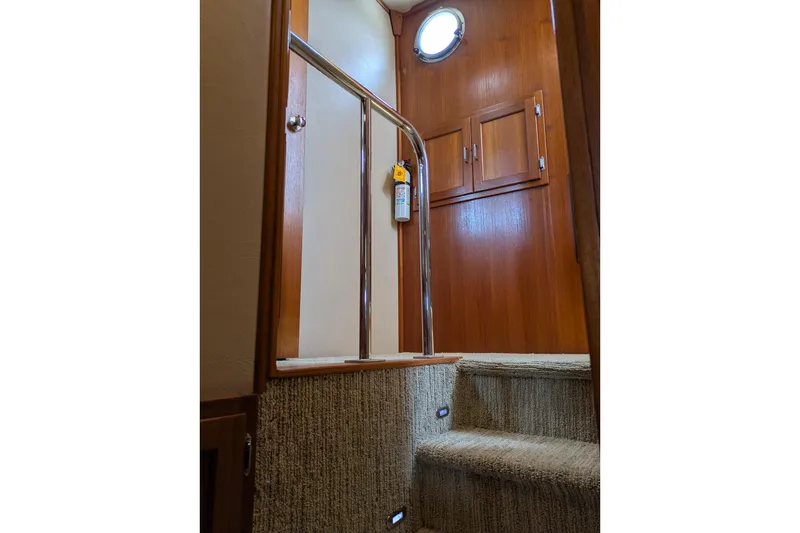 Slide: The Image of Staircase inside 2005 American Tug 41 boat with wooden paneling and carpeted steps. - 92