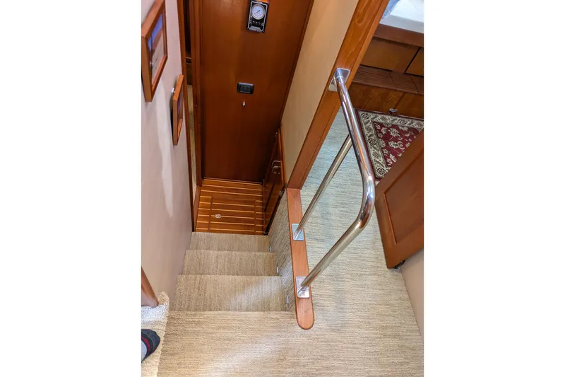 Slide: The Image of Staircase inside 2005 American Tug 41 yacht with wooden and carpeted steps. - 94