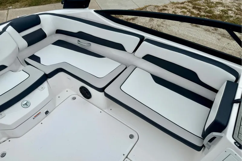 Slide: The Image of 2025 Yamaha Boats AR195 interior seating with sleek white and black upholstery design. - 11