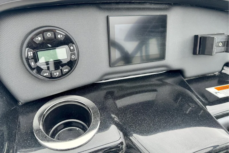 Slide: The Image of Dashboard of 2025 Yamaha Boats AR195 featuring control panel and cup holder. - 13