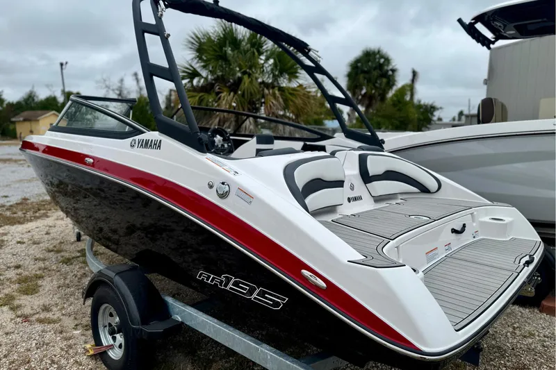 Slide: The Image of 2025 Yamaha AR195 boat with sleek design on a trailer, featuring red and black accents. - 2