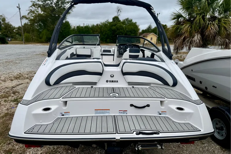 Slide: The Image of 2025 Yamaha Boats AR195, sleek design, rear view, white and black seating, outdoor setting. - 3