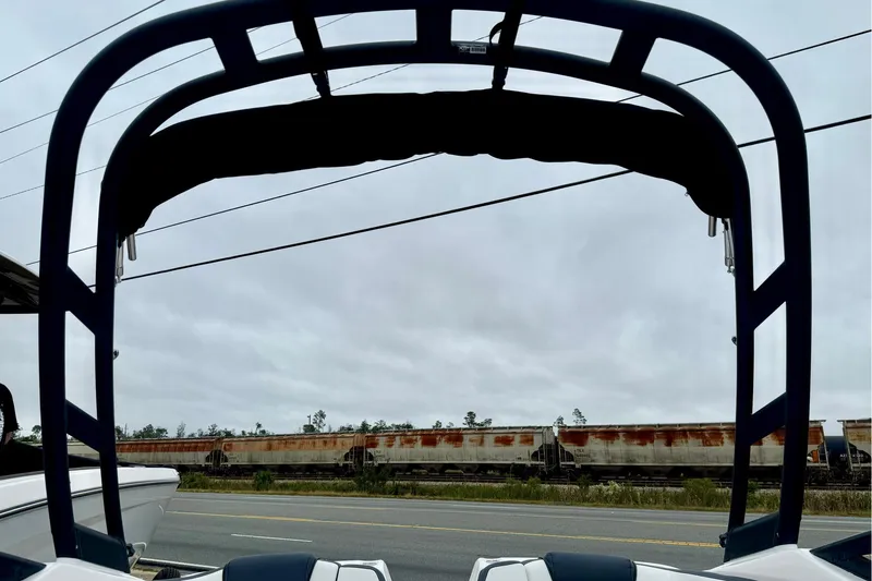 Slide: The Image of 2025 Yamaha Boats AR195 with wakeboard tower, parked near a road and train tracks. - 31