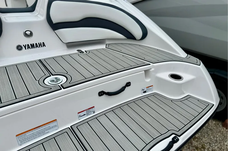 Slide: The Image of 2025 Yamaha Boats AR195 swim platform with sleek gray decking and comfortable seating. - 4