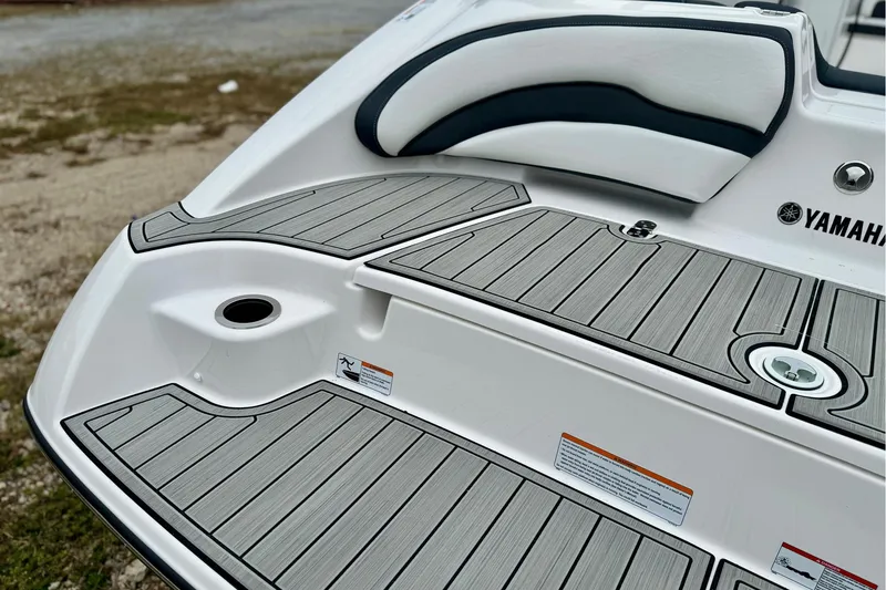 Slide: The Image of 2025 Yamaha Boats AR195 swim platform with sleek gray decking and comfortable seating. - 5