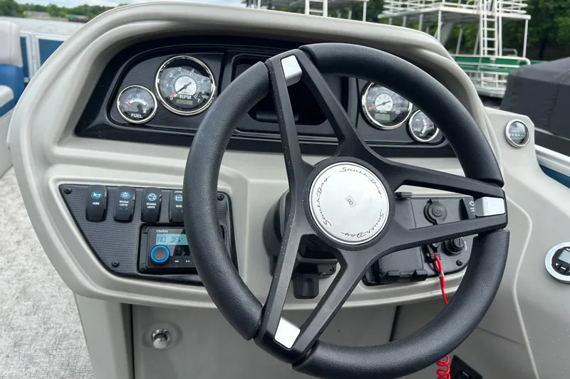 Slide: The Image of Steering wheel and dashboard of 2025 Southbay 224RSLE25 boat, featuring gauges and controls. - 14