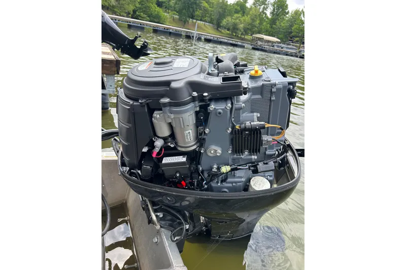 Slide: The Image of Outboard motor of a 2025 Southbay 224RSLE25 boat on a lake. - 25