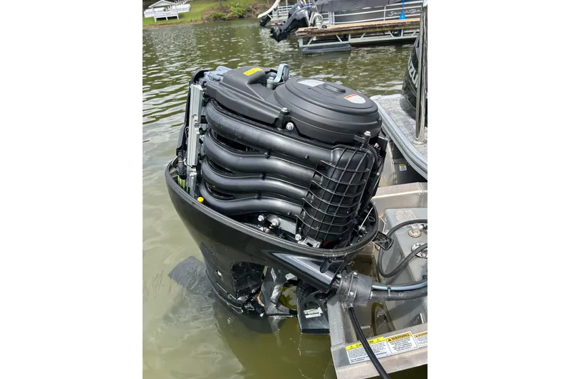 Slide: The Image of Outboard motor of a 2025 Southbay 224RSLE25 boat in water. - 26