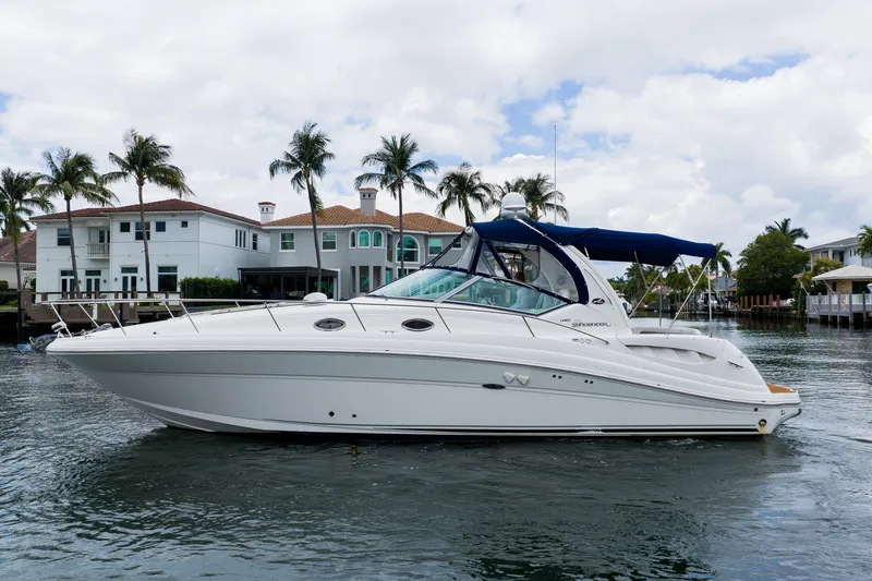 The Image of 2007 Sea Ray 340 Sundancer yacht on water, with luxury homes and palm trees in background. - 1