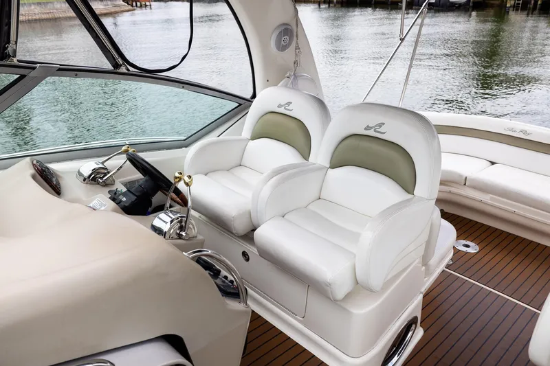 Slide: The Image of 2007 Sea Ray 340 Sundancer cockpit with plush white seating and sleek control panel. - 17