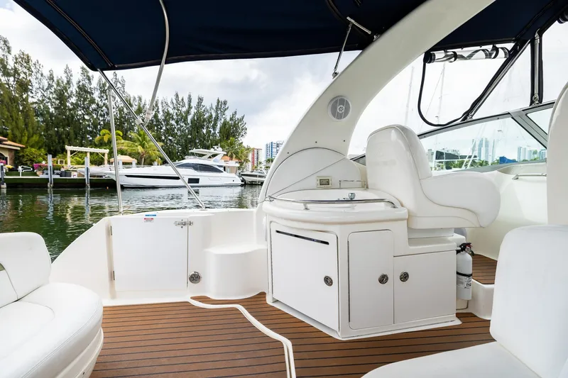 Slide: The Image of 2007 Sea Ray 340 Sundancer yacht interior with seating and kitchenette, docked by waterfront. - 27