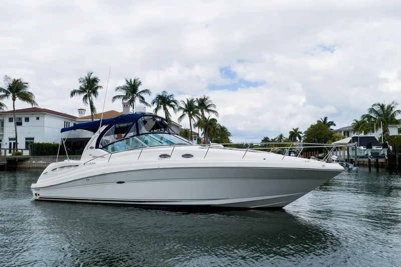 Slide: The Image of 2007 Sea Ray 340 Sundancer yacht cruising near waterfront homes and palm trees. - 3