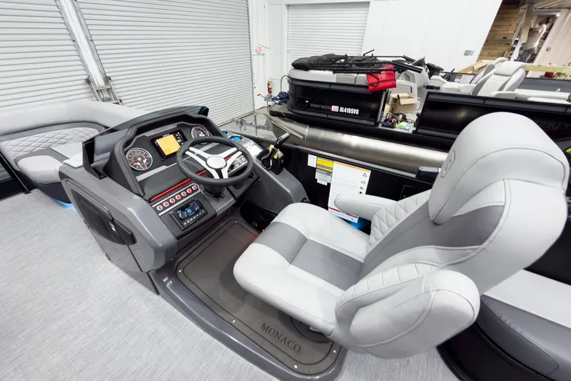Slide: The Image of Interior view of 2026 Godfrey Monaco 25' Tritoon, featuring modern helm and seating. - 20