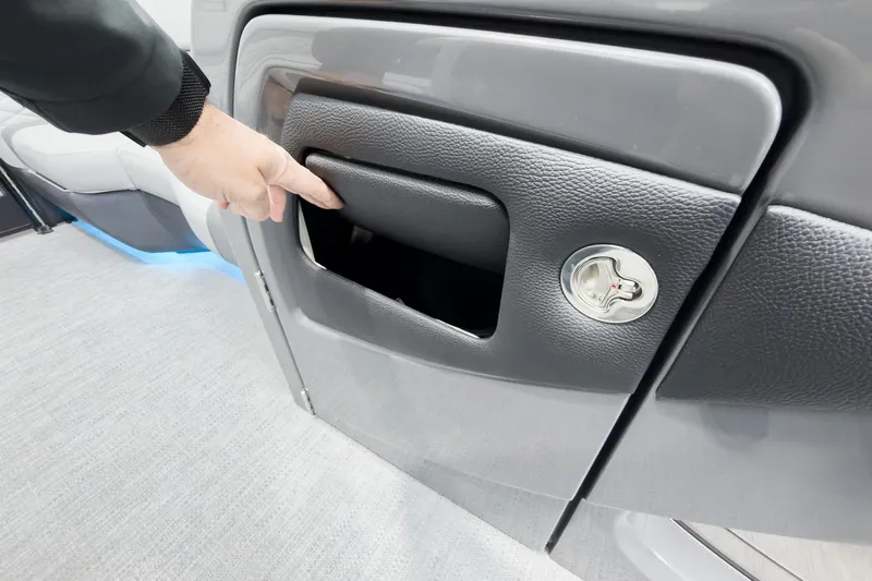 Slide: The Image of Hand opening storage compartment on 2026 Godfrey Monaco 25' Tritoon boat. - 27
