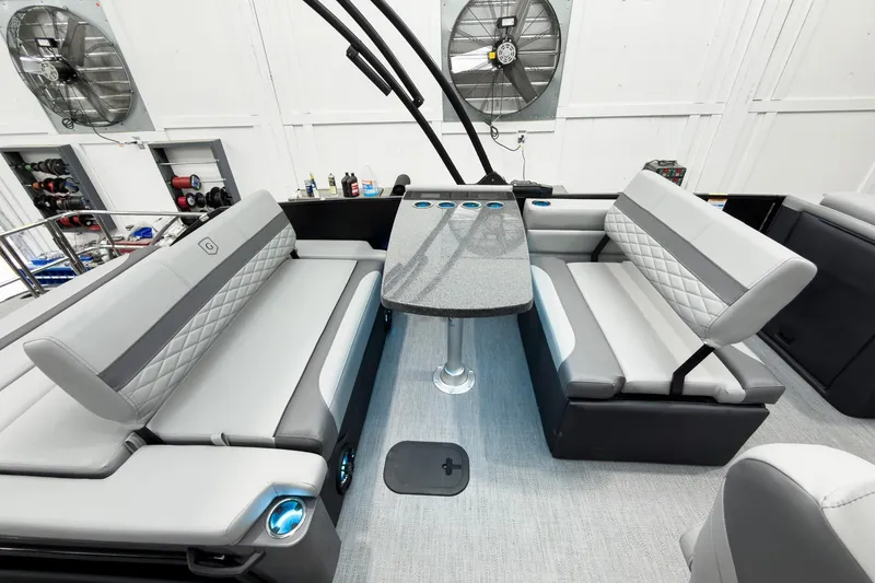 Slide: The Image of 2026 Godfrey Monaco 25' Tritoon interior with mid-table flip lounge seating. - 33