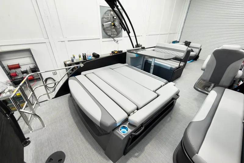 Slide: The Image of 2026 Godfrey Monaco 25' Tritoon with luxurious mid-table flip lounge seating. - 43