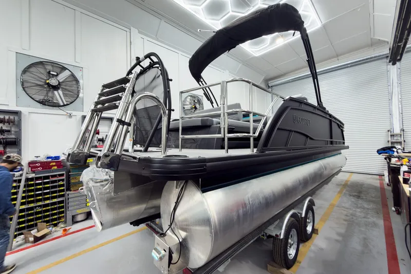 Slide: The Image of 2026 Godfrey Monaco 25' Tritoon in workshop, showcasing sleek design and modern features. - 8