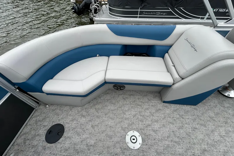 Slide: The Image of Luxurious seating on 2025 Southbay 224RSLE275 pontoon boat, featuring blue and gray upholstery. - 11