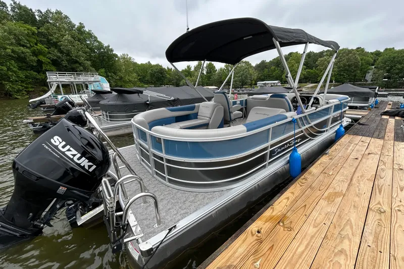 Slide: The Image of 2025 Southbay 224RSLE275 pontoon boat docked, featuring Suzuki outboard motor. - 23