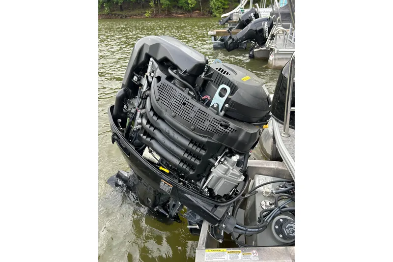 Slide: The Image of Outboard motor on a 2025 Southbay 224RSLE275 pontoon boat, docked on a lake. - 31