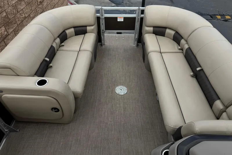 Slide: The Image of 2024 Sun Tracker SportFish 22 DLX pontoon boat interior with beige seating and cup holders. - 11