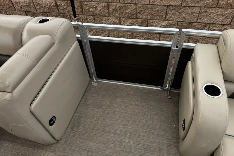 Slide: The Image of 2024 Sun Tracker SportFish 22 DLX boat interior with beige seating and cup holders. - 15