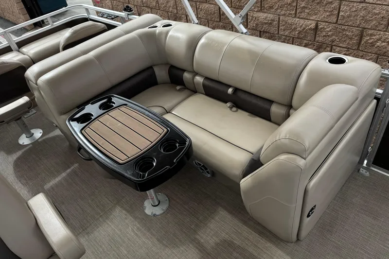 Slide: The Image of 2024 Sun Tracker SportFish 22 DLX interior with beige seating and a central table. - 18