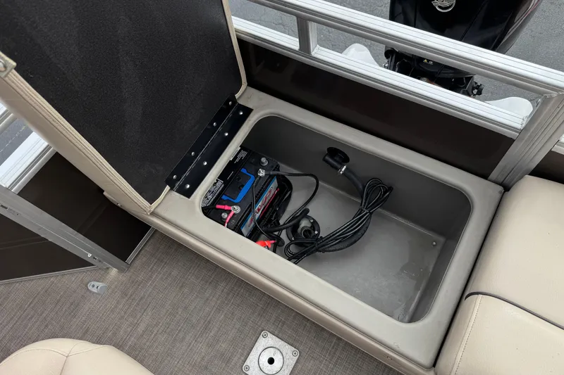 Slide: The Image of 2024 Sun Tracker SportFish 22 DLX storage compartment with battery and cables. - 20
