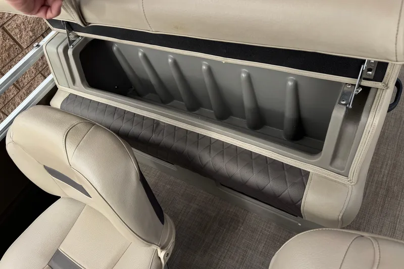 Slide: The Image of 2024 Sun Tracker SportFish 22 DLX boat seat storage compartment, open with beige upholstery. - 23