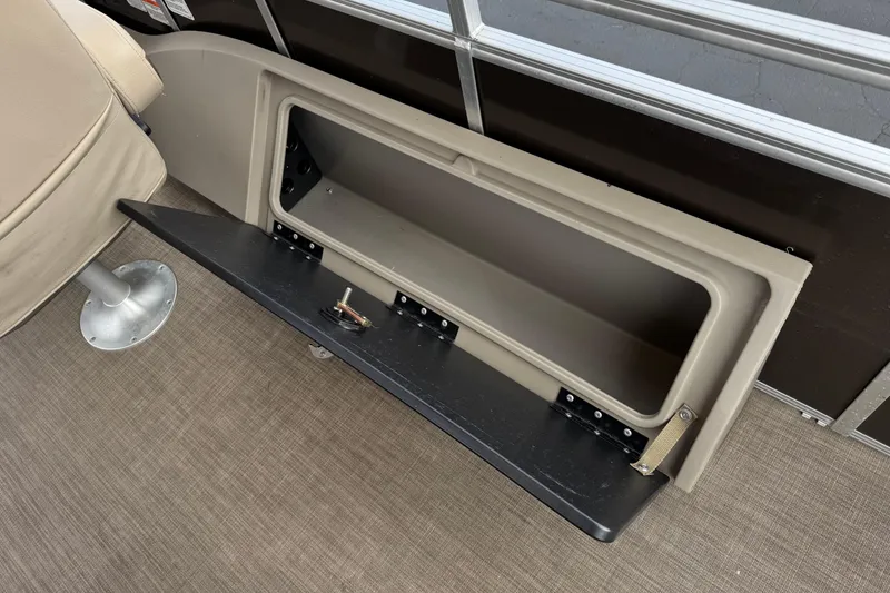 Slide: The Image of 2024 Sun Tracker SportFish 22 DLX storage compartment with open hatch on boat deck. - 25