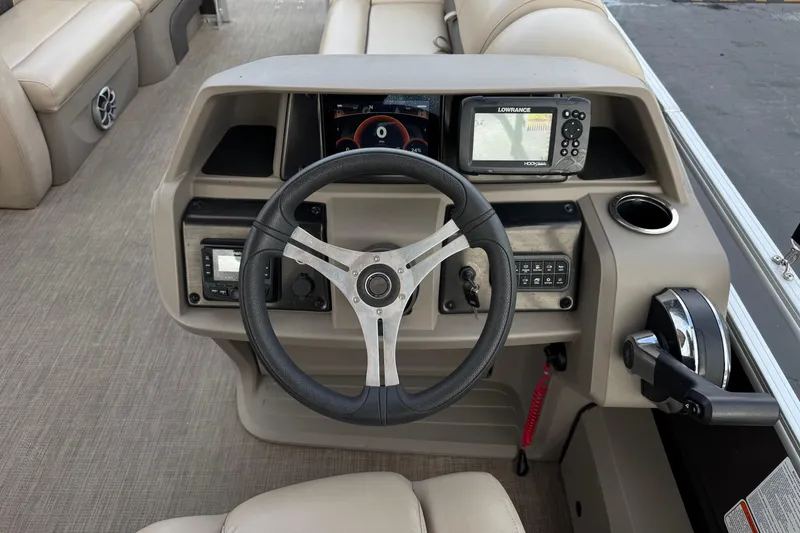 Slide: The Image of 2024 Sun Tracker SportFish 22 DLX dashboard with steering wheel and navigation system. - 27