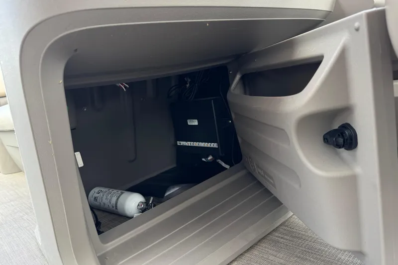Slide: The Image of Storage compartment of 2024 Sun Tracker SportFish 22 DLX with fire extinguisher. - 32