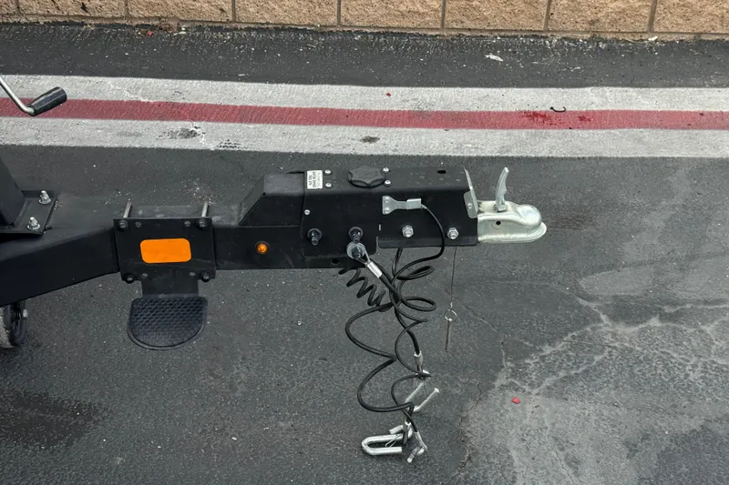 Slide: The Image of Trailer hitch of a 2024 Sun Tracker SportFish 22 DLX on asphalt pavement. - 34
