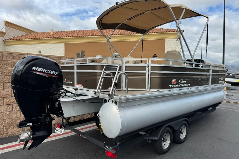 Slide: The Image of 2024 Sun Tracker SportFish 22 DLX pontoon boat with Mercury outboard motor on trailer. - 6