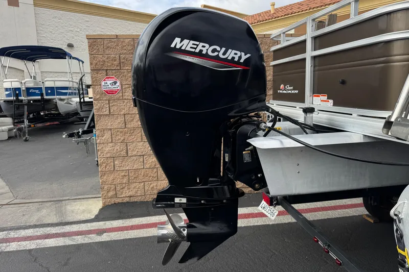 Slide: The Image of 2024 Sun Tracker SportFish 22 DLX with Mercury outboard motor in a dealership lot. - 8