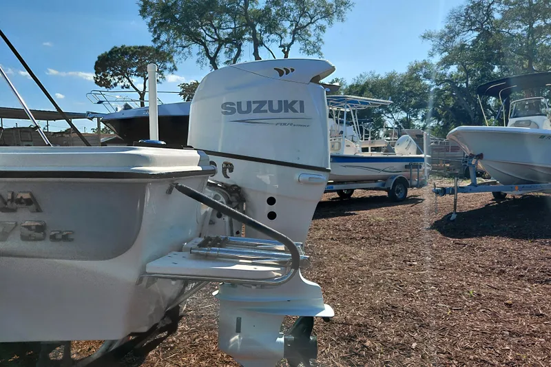 Slide: The Image of 2022 Carolina Skiff 178 JLS with Suzuki outboard motor in a boatyard setting. - 10