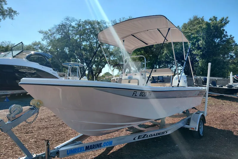 Slide: The Image of 2022 Carolina Skiff 178 JLS boat on trailer, parked outdoors under clear sky. - 3