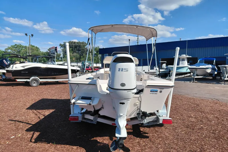Slide: The Image of 2022 Carolina Skiff 178 JLS boat with outboard motor, parked outdoors under blue sky. - 6