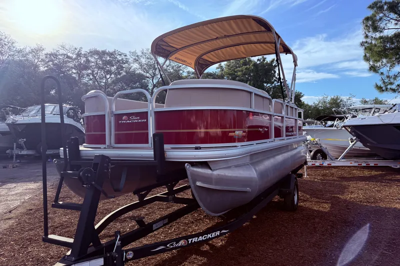 The Image of 2023 Sun Tracker Party Barge 18 DLX pontoon boat on trailer, sunny day. - 1