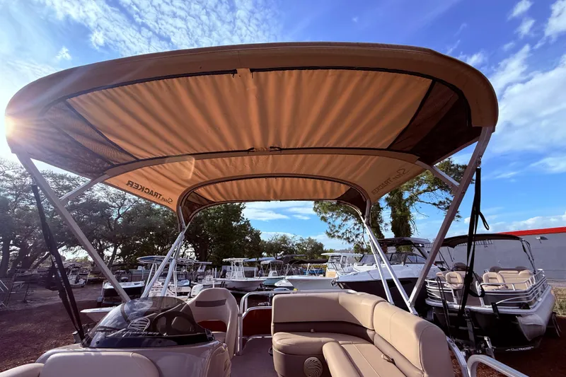 Slide: The Image of 2023 Sun Tracker Party Barge 18 DLX pontoon boat with canopy, parked outdoors. - 10