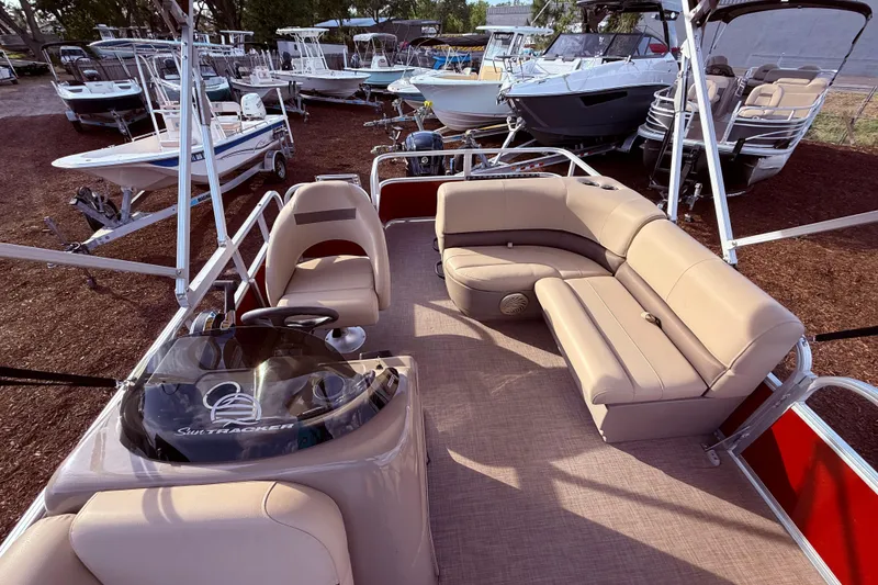 Slide: The Image of 2023 Sun Tracker Party Barge 18 DLX pontoon boat with beige seating and steering console. - 6