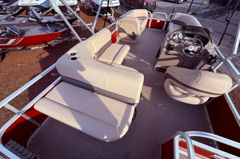 Slide: The Image of 2023 Sun Tracker Party Barge 18 DLX interior with beige seating and steering console. - 7