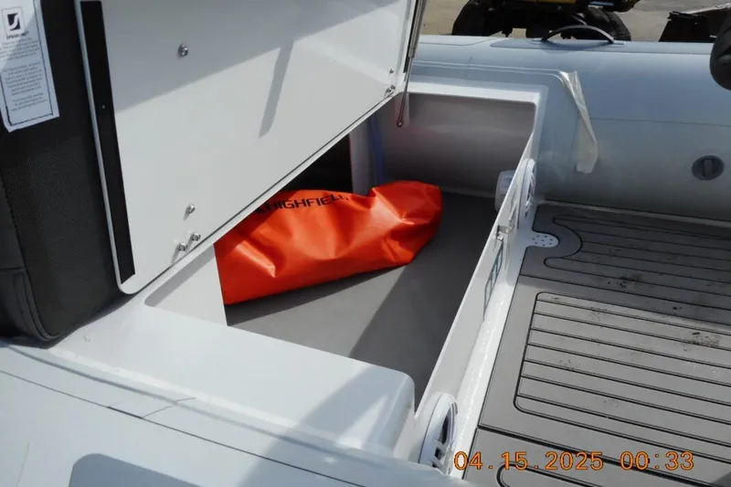 Slide: The Image of Open storage compartment in 2025 Highfield Sport 420 boat with orange bag inside. - 6