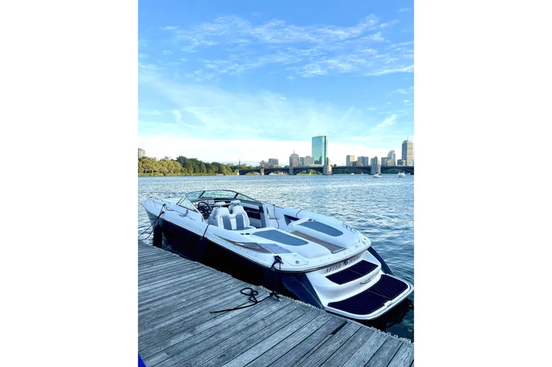 Slide: The Image of 2005 Cobalt 343 boat docked by city skyline under blue sky. - 1