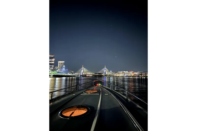 Slide: The Image of Night view from a 2005 Cobalt 343 boat, approaching a city bridge over calm waters. - 13
