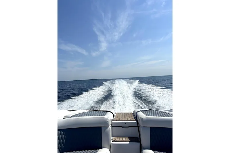 Slide: The Image of 2005 Cobalt 343 boat cruising on open water under a clear blue sky. - 14