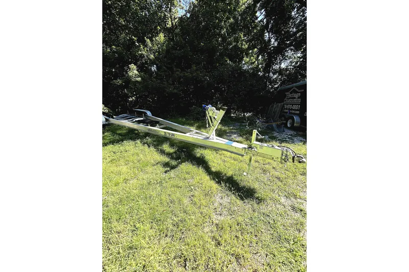 Slide: The Image of Trailer for 2005 Cobalt 343 boat on grassy area, surrounded by trees. - 17