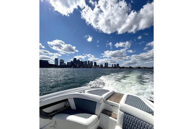 Slide: The Image of Boat cruising on water with city skyline and cloudy sky, Cobalt 343, 2005 model. - 6